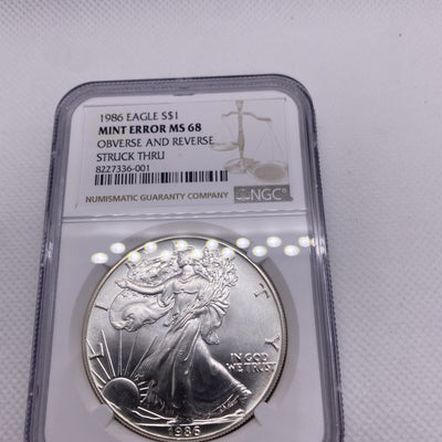 1986 $1 AMERICAN SILVER EAGLE NGC MS68 OBVERSE & REVERSE STRUCK THRU MINT ERROR